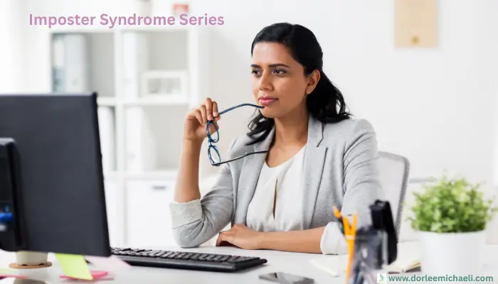 A thoughtful professional woman at her desk, reflecting, hero image for blog post “The Perfectionist’s Dilemma: Success Without Satisfaction” from the Imposter Syndrome Series.